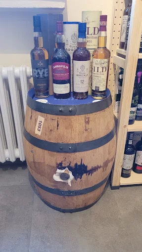 Whiskyflaschen auf einem Holzfass